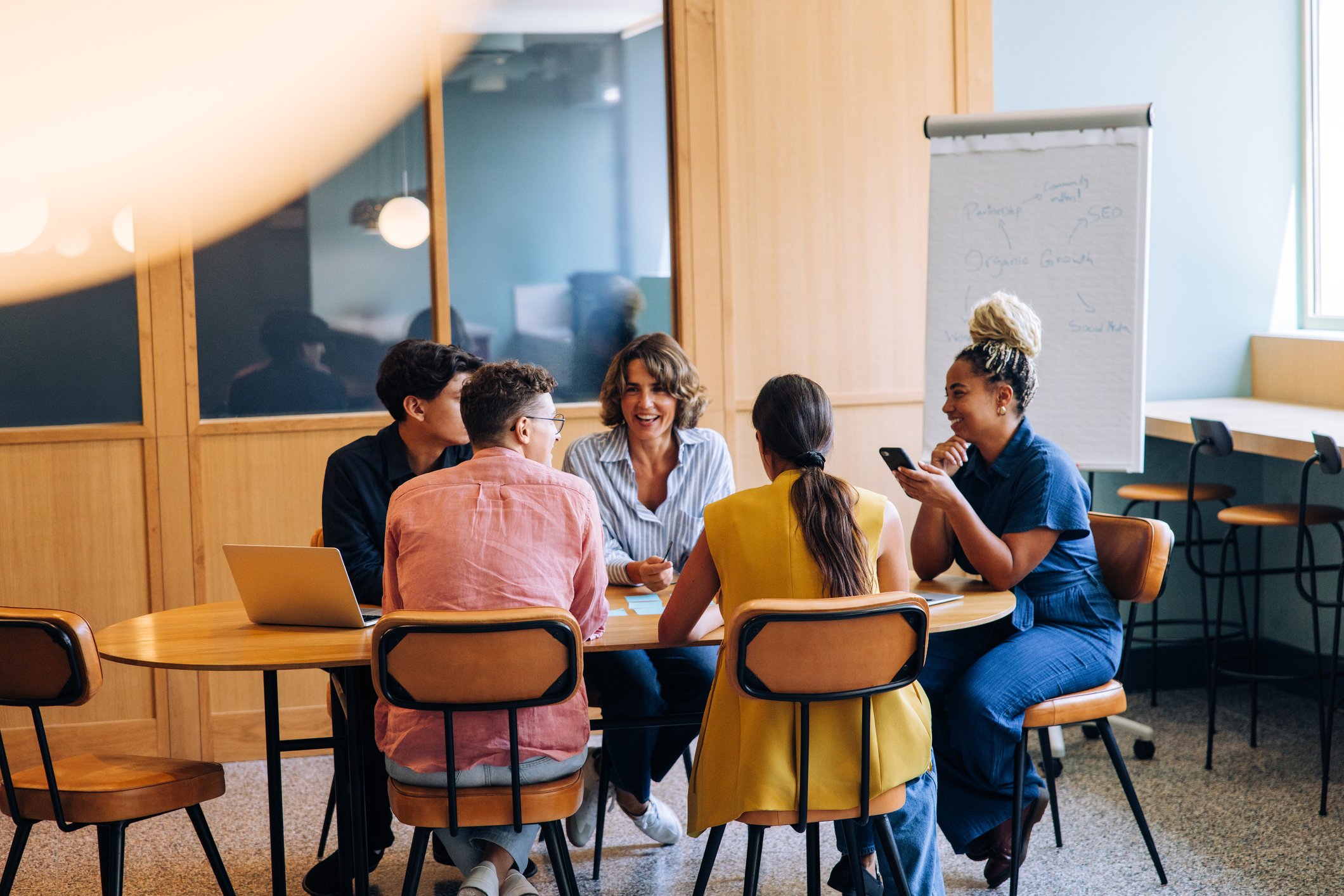 A group of colleagues discusses organizational change initiatives, which a change readiness assessment can help support