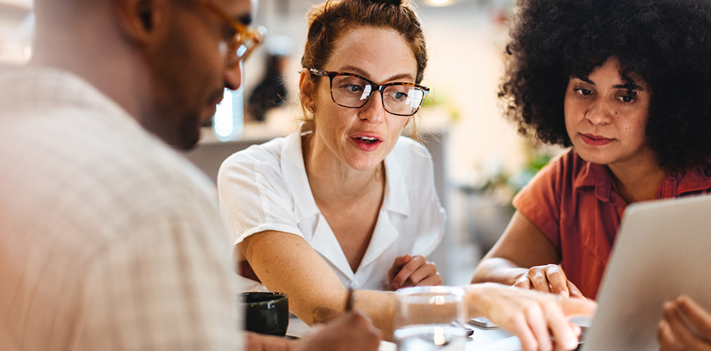 Employees in the middle of a strategic workforce planning meeting, discussing current workforce capabilities and skills gaps as part of their overall business strategy