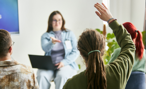 In a technology seminar with someone's hand raised to ask a question
