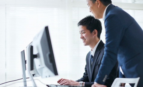 Colleague guiding man on computer